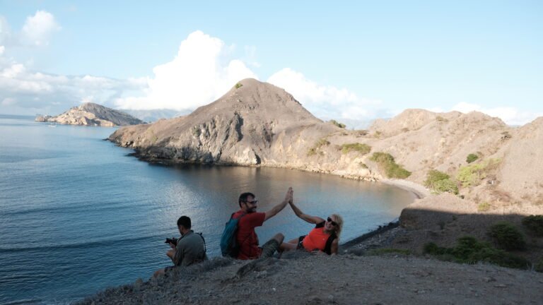 Tourists enjoying the scenic view from the hill at Padar Island in Komodo National Park near Labuan Bajo, Indonesia.