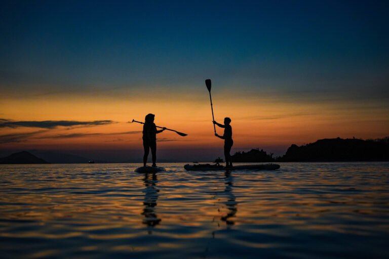 Sunset Labuan Bajo dengan aktivitas paddle board di laut tenang, wisata seru bersama visit labuan bajo”