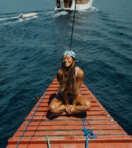 Woman enjoying a Komodo sailing trip on a phinisi boat in Labuan Bajo, Indonesia with beautiful ocean views during a tropical island adventure by Visit Labuan Bajo Komodo.