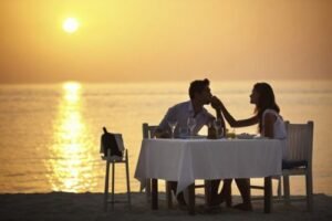 Romantic dinner in Komodo with a couple enjoying a private sunset dining experience by the beach in Labuan Bajo, Indonesia.