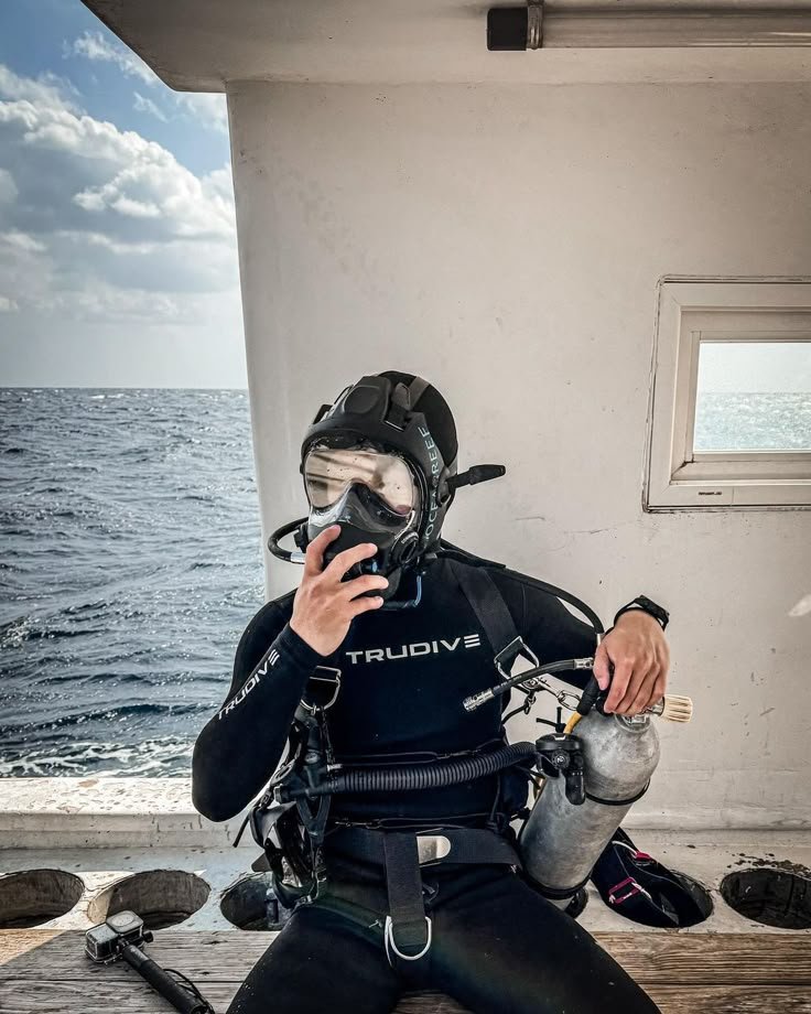 Penyelam profesional sedang bersiap melakukan scuba diving di perairan Taman Nasional Komodo menggunakan perlengkapan lengkap di atas kapal diving bersama Visit Labuan Bajo Komodo .