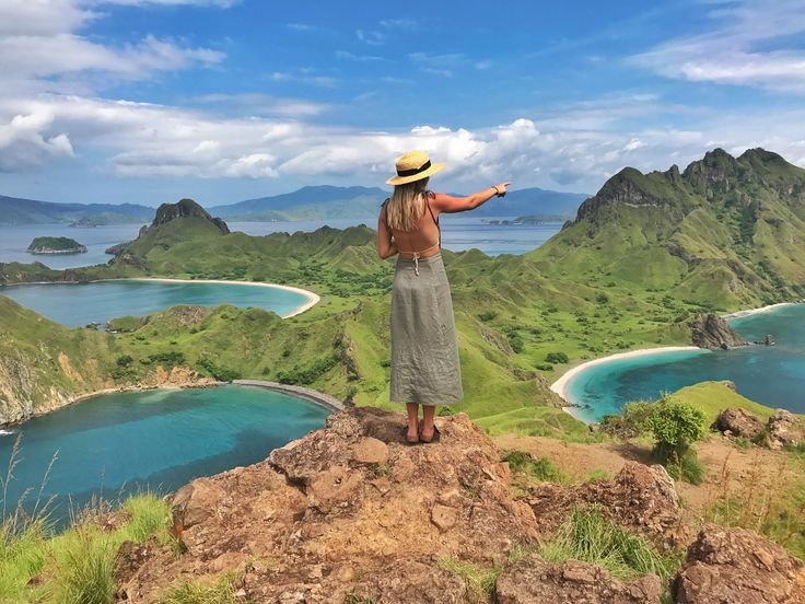 Female traveler enjoying the breathtaking Padar Island viewpoint in Komodo National Park, Labuan Bajo Indonesia during a Flores island adventure and luxury travel experience.
