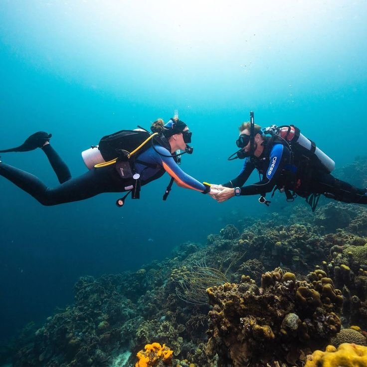 Couple enjoying a romantic scuba diving experience in Labuan Bajo surrounded by colorful coral reefs and clear blue waters in Komodo National Park.