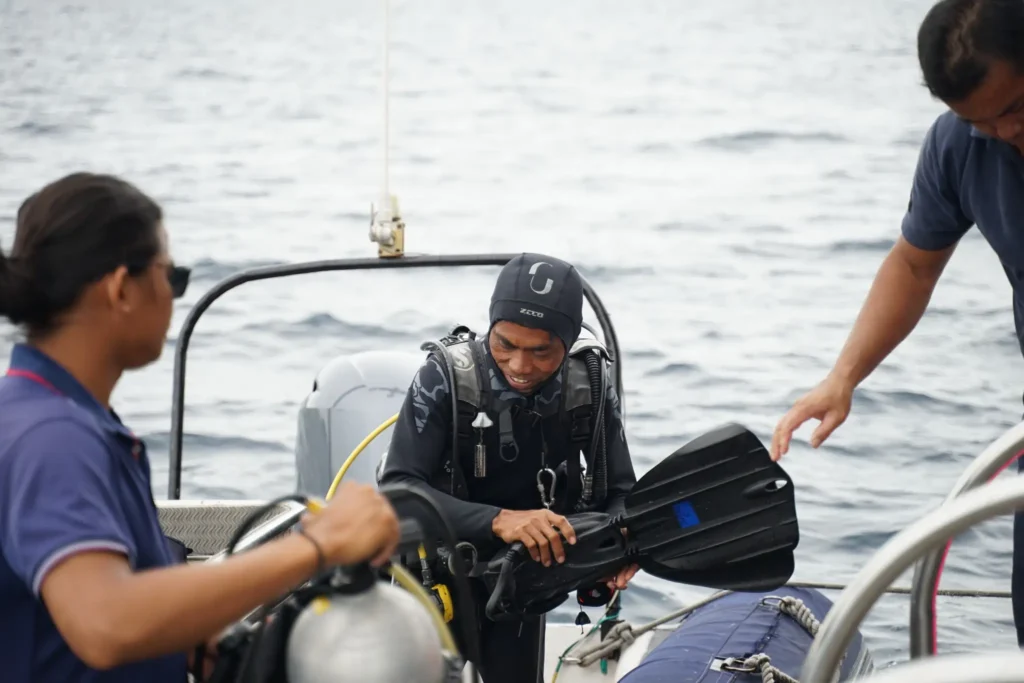 Professional scuba divers prepare diving equipment on a boat in Labuan Bajo before exploring the underwater world of Komodo National Park.