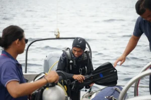 Professional scuba divers prepare diving equipment on a boat in Labuan Bajo before exploring the underwater world of Komodo National Park.
