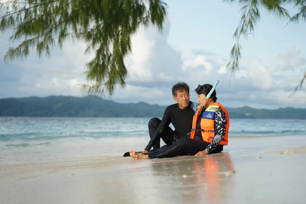 Couple enjoying a relaxing snorkeling experience on a pristine tropical beach in Labuan Bajo, Indonesia, during a private Komodo Island tour with Visit Labuan Bajo Komod