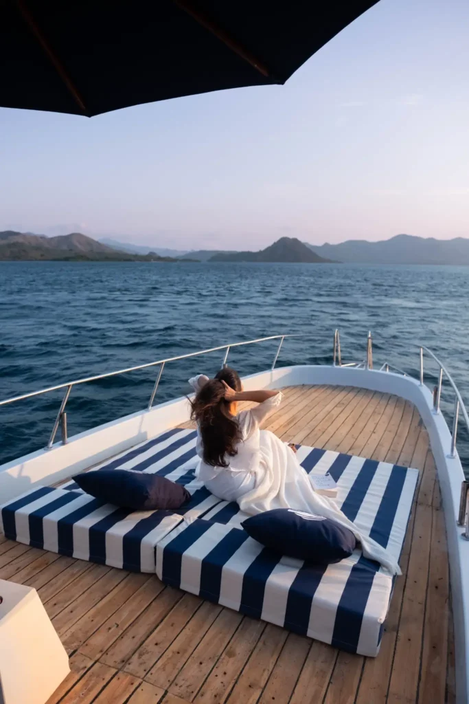 Luxury yacht sundeck overlooking Komodo National Park during sunset in Labuan Bajo by Visit Labuan Bajo Komodo.
