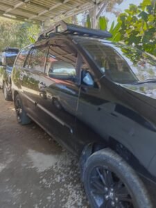 Black Toyota Innova rental in Labuan Bajo for private tours, airport transfers, and overland Flores expeditions with professional local driver