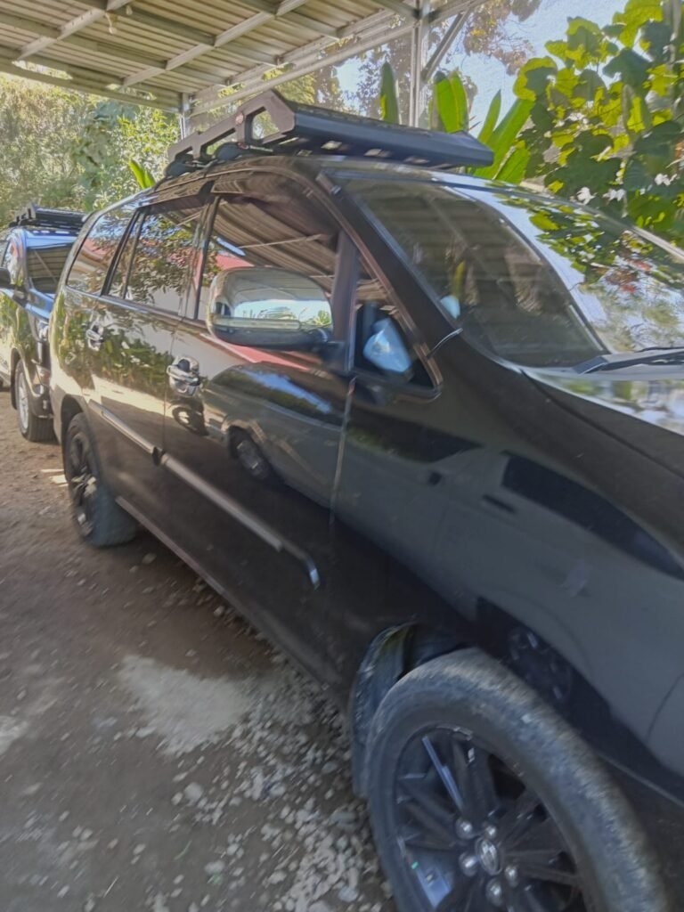 Black Toyota Innova rental in Labuan Bajo for private tours, airport transfers, and overland Flores expeditions with professional local driver